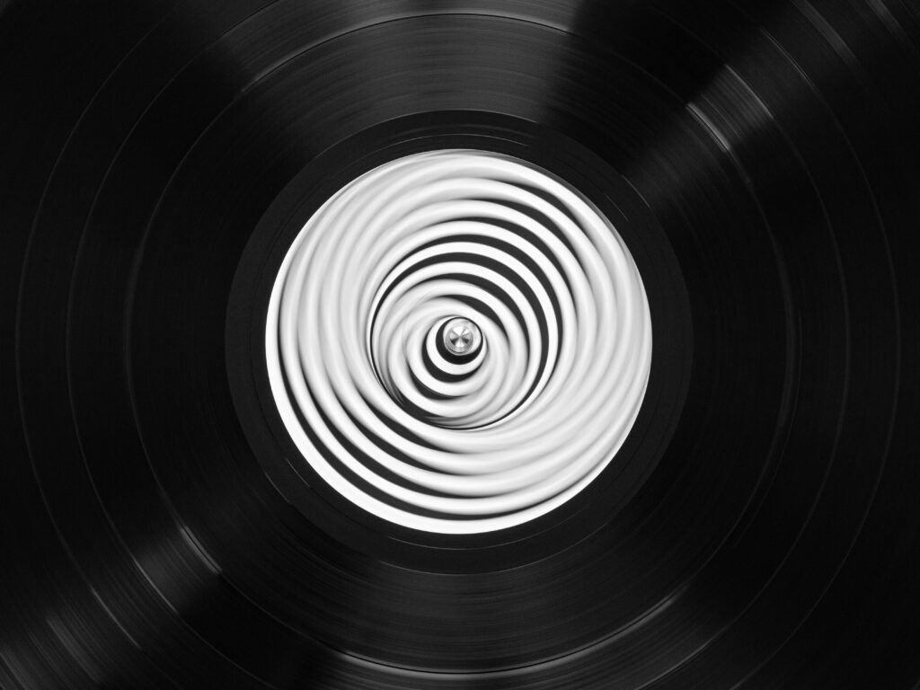 Black and white close-up of a spinning vintage vinyl record creating a mesmerizing swirl pattern.