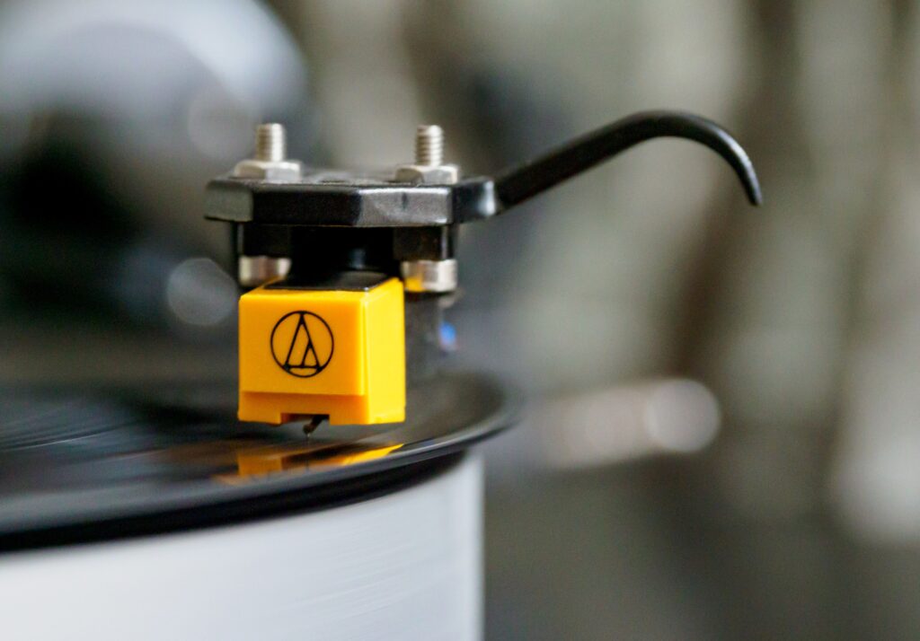 Detailed close-up image of a turntable stylus on a spinning vinyl record, showcasing analog music technology.