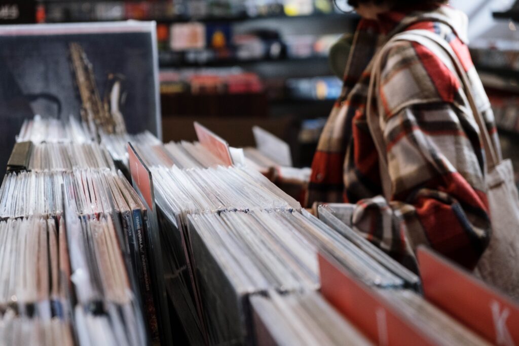 Exploring classic vinyl records in a cozy vintage shop, perfect for music enthusiasts.